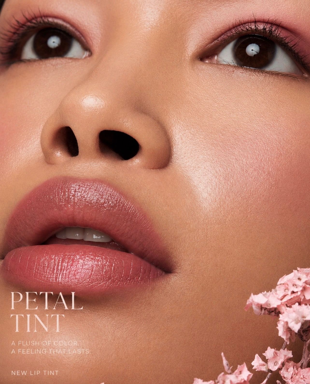 Beauty editorial close-up with soft pink lip tint and blossoms