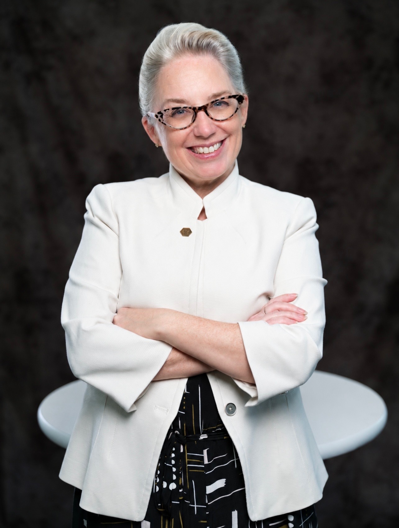 Executive portrait of a smiling professional in a white blazer