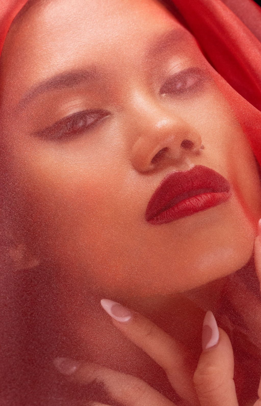 Beauty portrait behind red veil